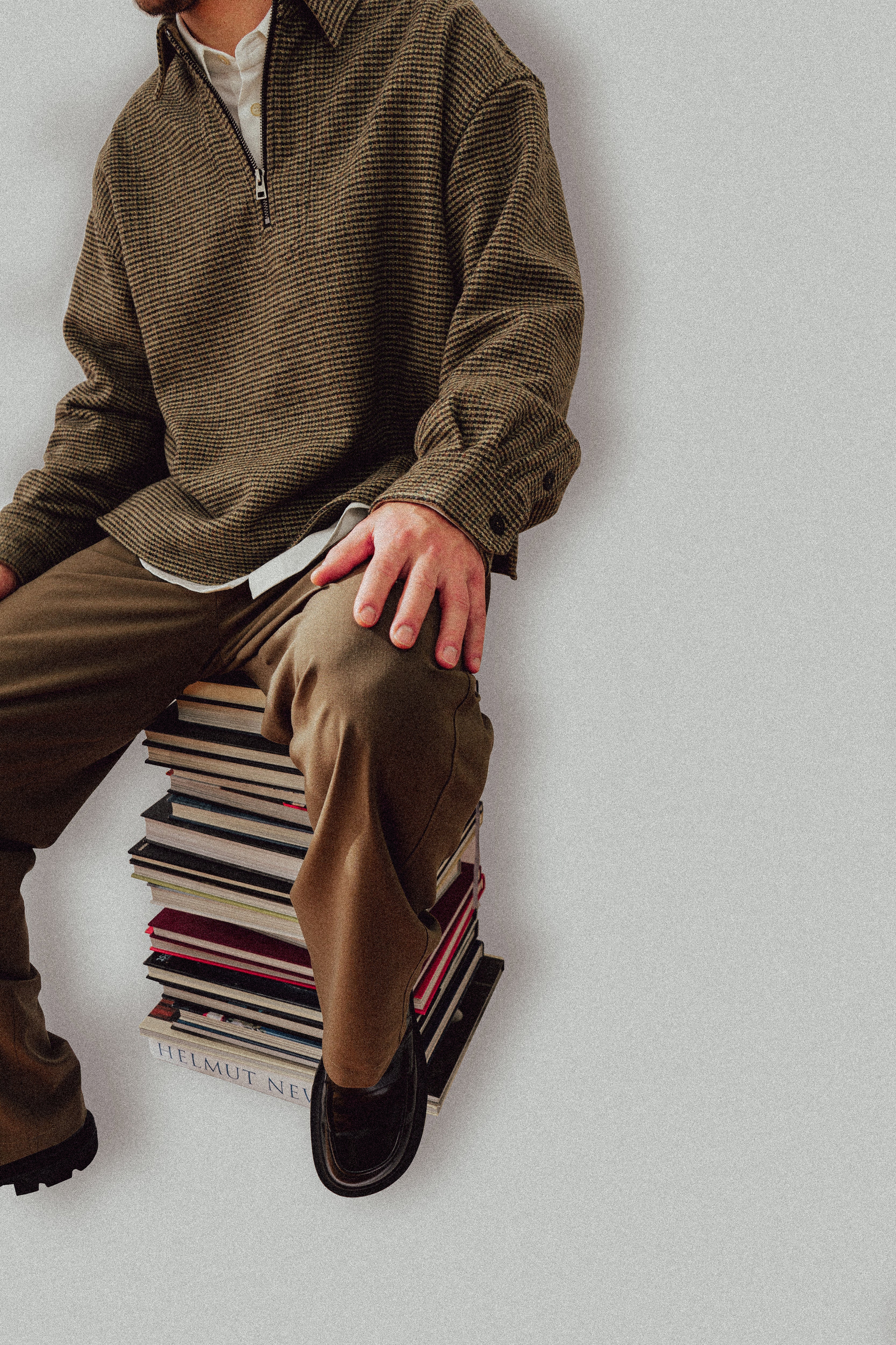 Model wearing Houndstooth Wooltroyer from Misela Studios and sitting on stake of books