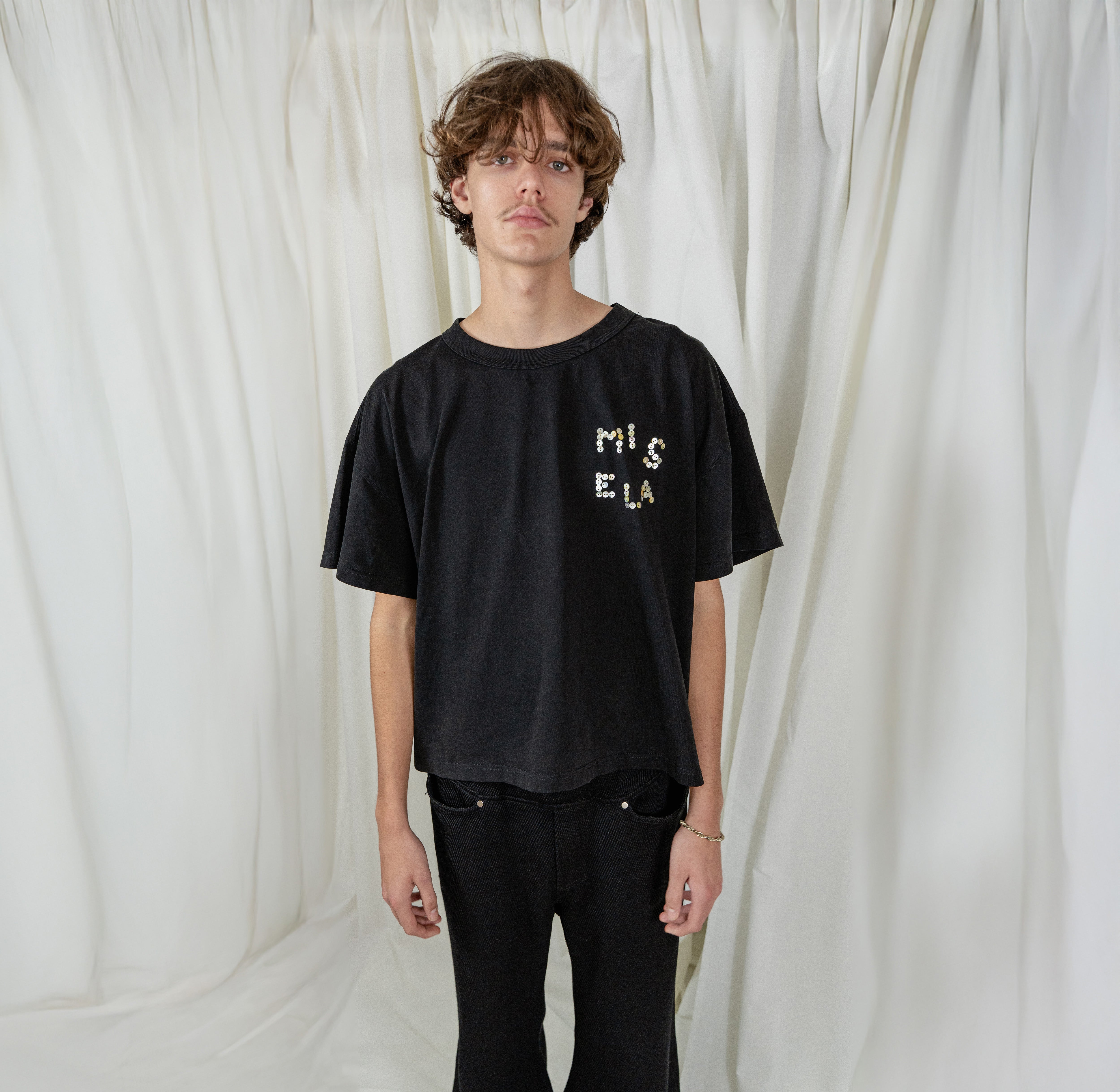 Model is wearing Signature Pearl Tee from Misela Studios in black